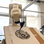 Photo of a robot arm drawing a design